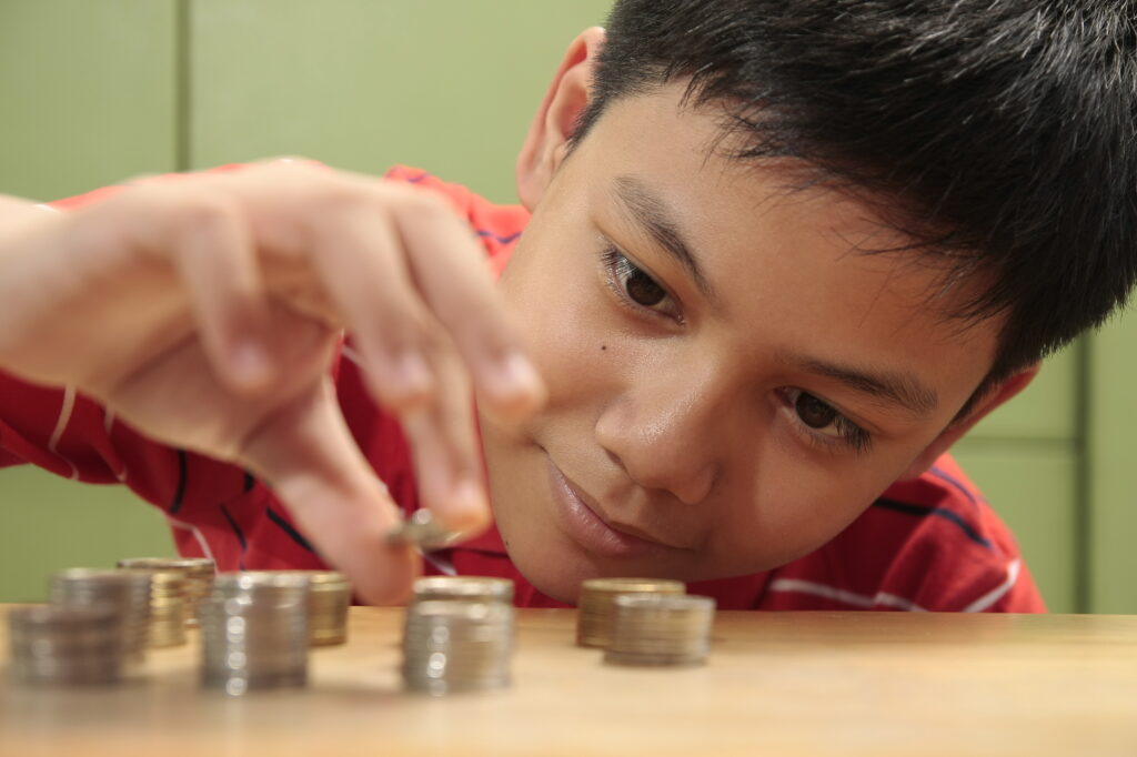 Boy inspecting stacked coins