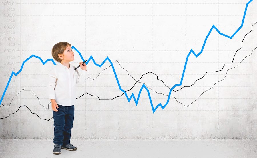 Investing for kids boy in front of a large stock chart