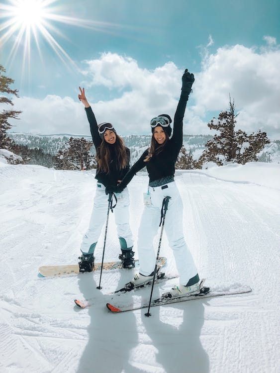 two young girls having fun skiing in the snow